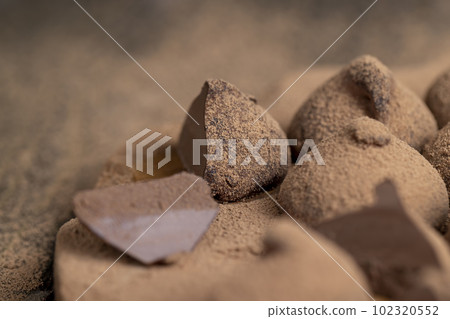 a large number of sweet candies in chocolate powder 102320552