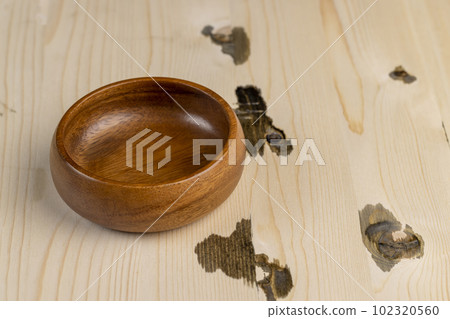 an empty wooden bowl of dark color on a white board an empty wooden bowl of dark color on a white board 102320560