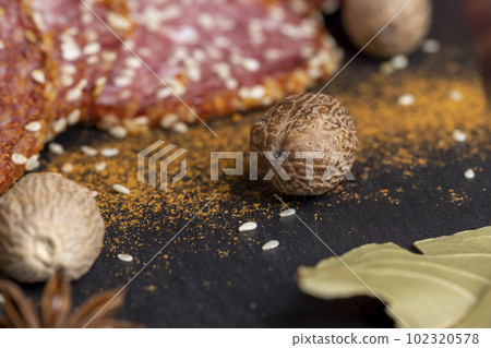 Whole nutmeg and other spices with sausage on the table Whole nutmeg and other spices with sausage on the table 102320578