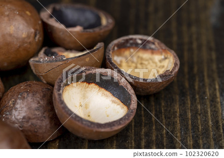 Unpeeled macadamia nuts on the table 102320620