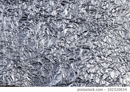 crumpled thin aluminum foil reflecting light 102320634