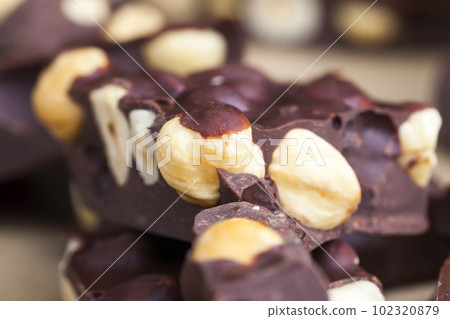 Pieces of homemade milk chocolate with lots of hazelnuts Pieces of homemade milk chocolate with lots of hazelnuts 102320879