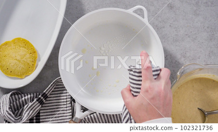 Step by step. Flat lay. Frying pumpkin pancakes batter on a white frying pan. 102321736
