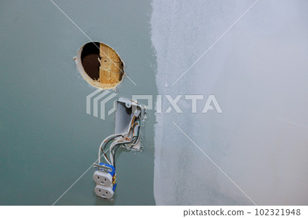 Installation of new current socket by an electrician working in construction site for new house safety Installation of new current socket by an electrician working in construction site for new house safety 102321948