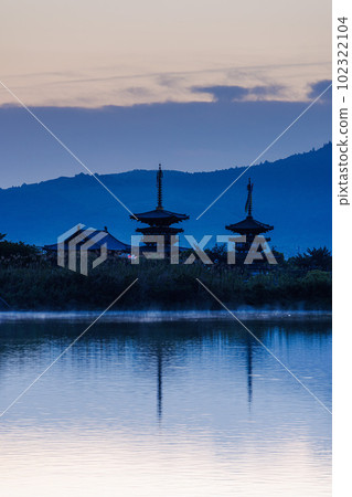 Yakushiji Temple in Nara, where the gradation of the sky reflected on the surface of Oike is beautiful 102322104