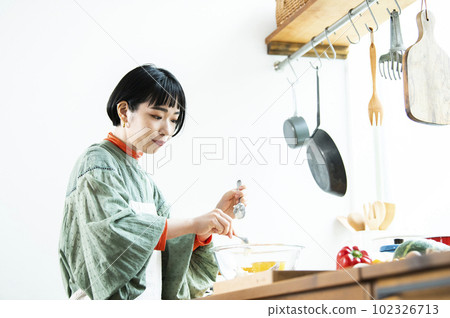 Young woman making pumpkin pancakes Young woman making pumpkin pancakes 102326713