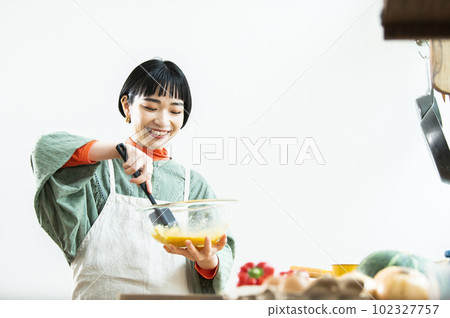 Young woman making pumpkin pancakes Young woman making pumpkin pancakes 102327757