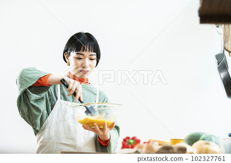 Young woman making pumpkin pancakes Young woman making pumpkin pancakes 102327761