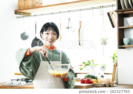 Young woman making pumpkin pancakes 102327763