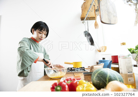 Young woman making pumpkin pancakes 102327764