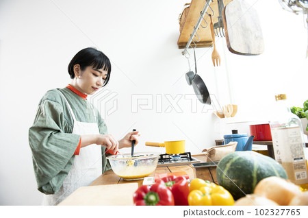 Young woman making pumpkin pancakes Young woman making pumpkin pancakes 102327765