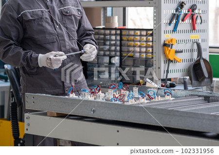 worker operates an automatic production line (PCB printer machine) in a workshop worker operates an automatic production line (PCB printer machine) in a workshop 102331956