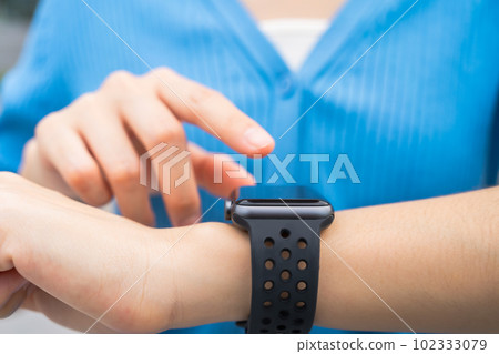 Woman wearing a smartwatch and touching to check on o'clock. Woman wearing a smartwatch and touching to check on o'clock. 102333079