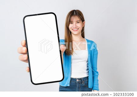 Beautiful Asian woman holding smartphone mockup of blank screen and smiling on white background. 102333100