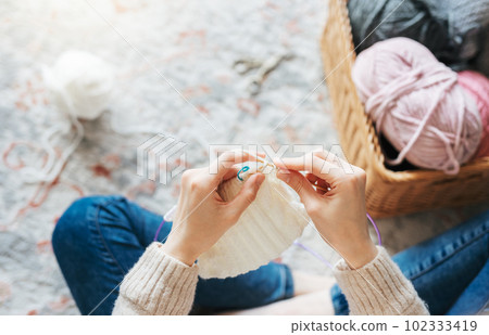 Young woman knitting warm scarf indoors Young woman knitting warm scarf indoors 102333419