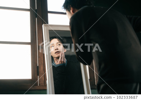 A man checking the condition of his skin A man checking the condition of his skin 102333687