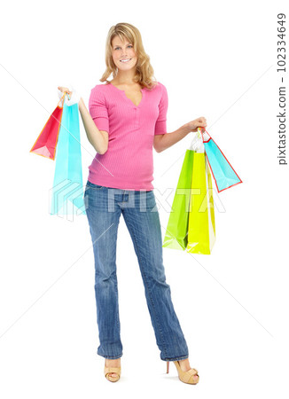 I might have over-indulged. Full length of a pretty young woman holding shopping bags while isolated on white. 102334649
