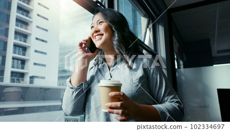 Business woman, phone call and coffee in communication, talking or conversation by window in corporate city building. Female manager or leader in discussion for strategy on smartphone at the office 102334697