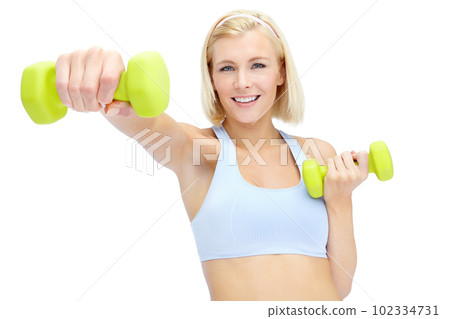 Im getting in shape. Sporty young woman lifting dumbbells while isolated on white. 102334731