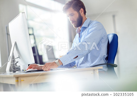 Waiting for inspiration to take over. a handsome designer sitting at his desk with his computer in front of him. 102335105