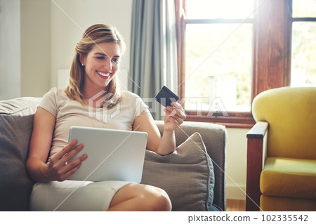 Getting in on the latest international trends without traveling. a young woman doing some online shopping on her digital tablet. Getting in on the latest international trends without traveling. a young woman doing some online shopping on her digital tablet. 102335542