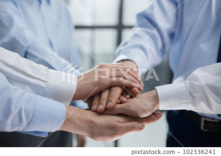 Close up on colleagues hands all together 102336241