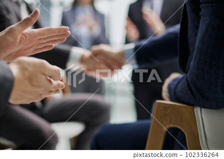 Business colleagues shaking hands in an office hallway 102336264
