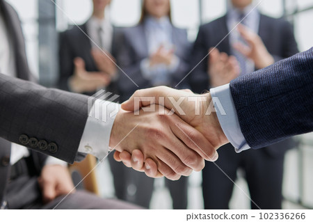 businessman and businesswoman shaking hands in hallway. businessman and businesswoman shaking hands in hallway. 102336266