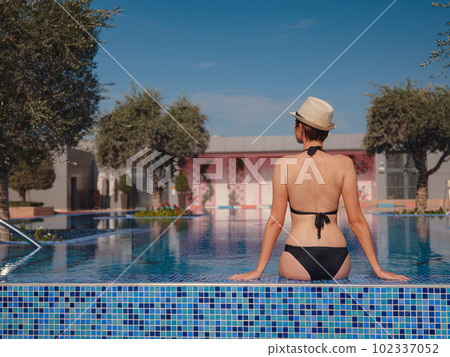 asian woman relaxing in swimming pool spa 102337052