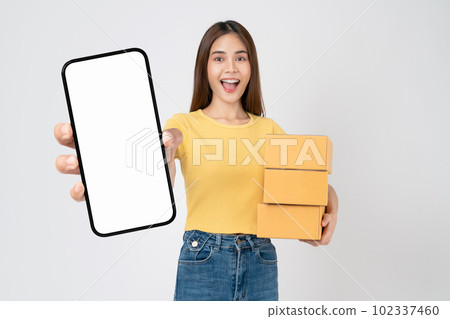 woman holding cardboard boxes and hands show smartphone mockup of blank screen on white background. 102337460
