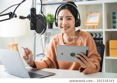 woman holding digital tablet and use microphones wear headphones with laptop. 102338143