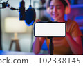 woman wearing headphones with live streaming on mobile and smartphone mockup of blank screen. 102338145