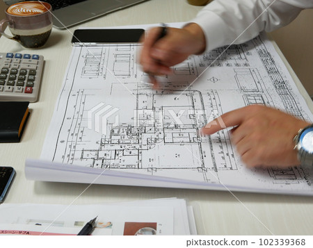 Male employee writing blueprints in-house 102339368