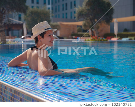 asian woman relaxing in swimming pool spa 102340751