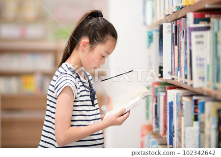 A girl choosing a book 102342642
