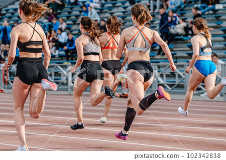rear view group female athlete runners running sprint race, summer athletics championships 102342838