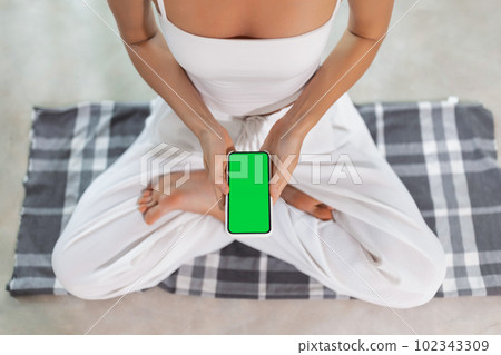 Sport App Close-Up, Attractive Woman's Hands Displaying App on Green Screen During Yoga Sport App Close-Up, Attractive Woman's Hands Displaying App on Green Screen During Yoga 102343309