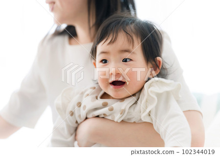 Mama feeding baby food to baby 102344019