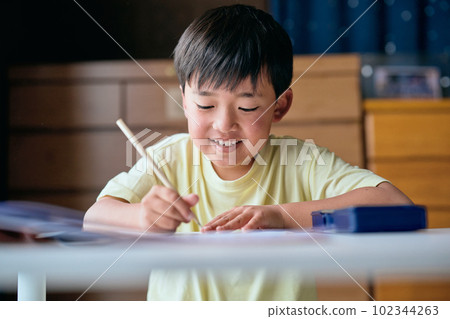 Elementary school boy practicing kanji at home Elementary school boy practicing kanji at home 102344263