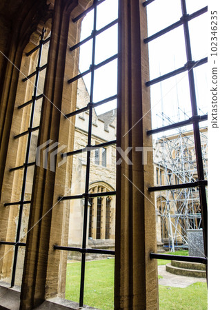 A historic stone building seen through a lattice window, the city of Oxford A historic stone building seen through a lattice window, the city of Oxford 102346235