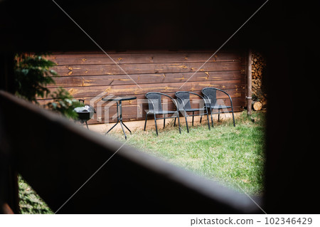 Vacation Home Grill and Chill with garden with BBQ. Vacation Home Rentals with Outdoor Grills. BBQ Family Picnic, Best BBQ Menu Ideas. Grill and chairs in the courtyard of country cottage Vacation Home Grill and Chill with garden with BBQ. Vacation Home Rentals with Outdoor Grills. BBQ Family Picnic, Best BBQ Menu Ideas. Grill and chairs in the courtyard of country cottage 102346429
