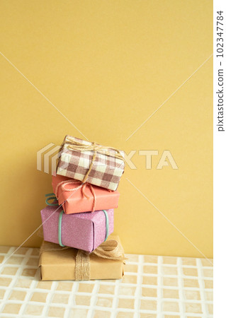 Gift boxes on table. yellow background. anniversary birthday party concept 102347784