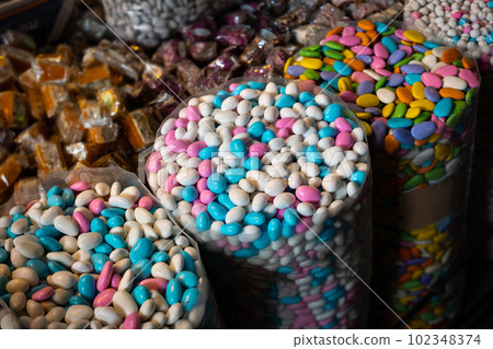 Bags of sweets, pile of coated almonds Bags of sweets, pile of coated almonds 102348374