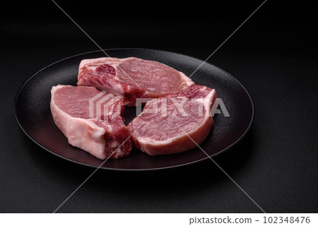 Raw pork on the bone or rib sliced with salt, spices and herbs Raw pork on the bone or rib sliced with salt, spices and herbs 102348476