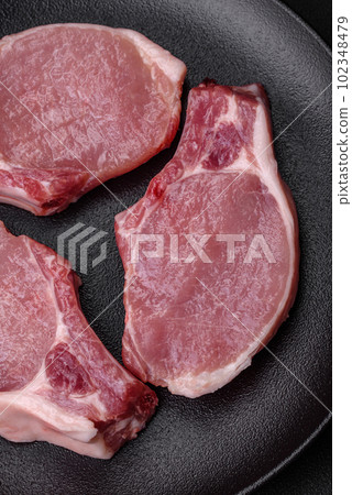 Raw pork on the bone or rib sliced with salt, spices and herbs Raw pork on the bone or rib sliced with salt, spices and herbs 102348479