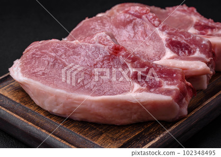 Raw pork on the bone or rib sliced with salt, spices and herbs Raw pork on the bone or rib sliced with salt, spices and herbs 102348495