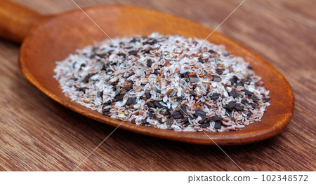 Medicinal herbs isabgul and basil seeds on a wooden spoon 102348572