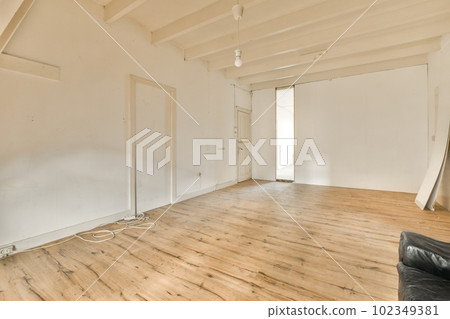 an empty living room with wood flooring and white walls in the room is being used as a place for painting 102349381