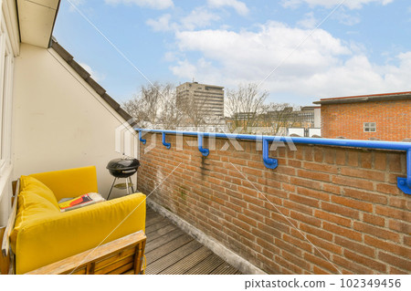 an outside area with a couch, chair and brick wall that has been painted to look like it's made out of bricks an outside area with a couch, chair and brick wall that has been painted to look like it's made out of bricks 102349456