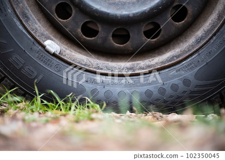 Old tire - tyre on ground detail Old tire - tyre on ground detail 102350045